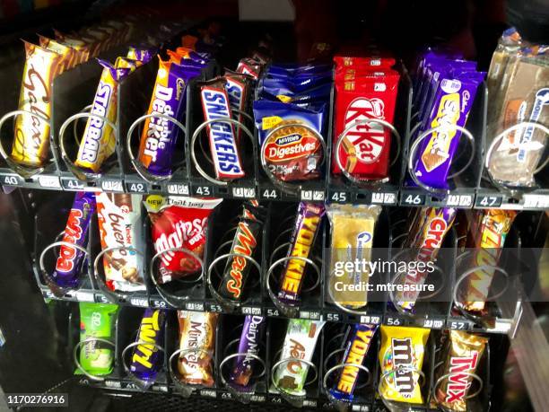 snacks+2 Manchester, Greater Manchester, England, UK - June, 16 2019: Image of chocolate bars, cakes and biscuits in a snack vending machine.